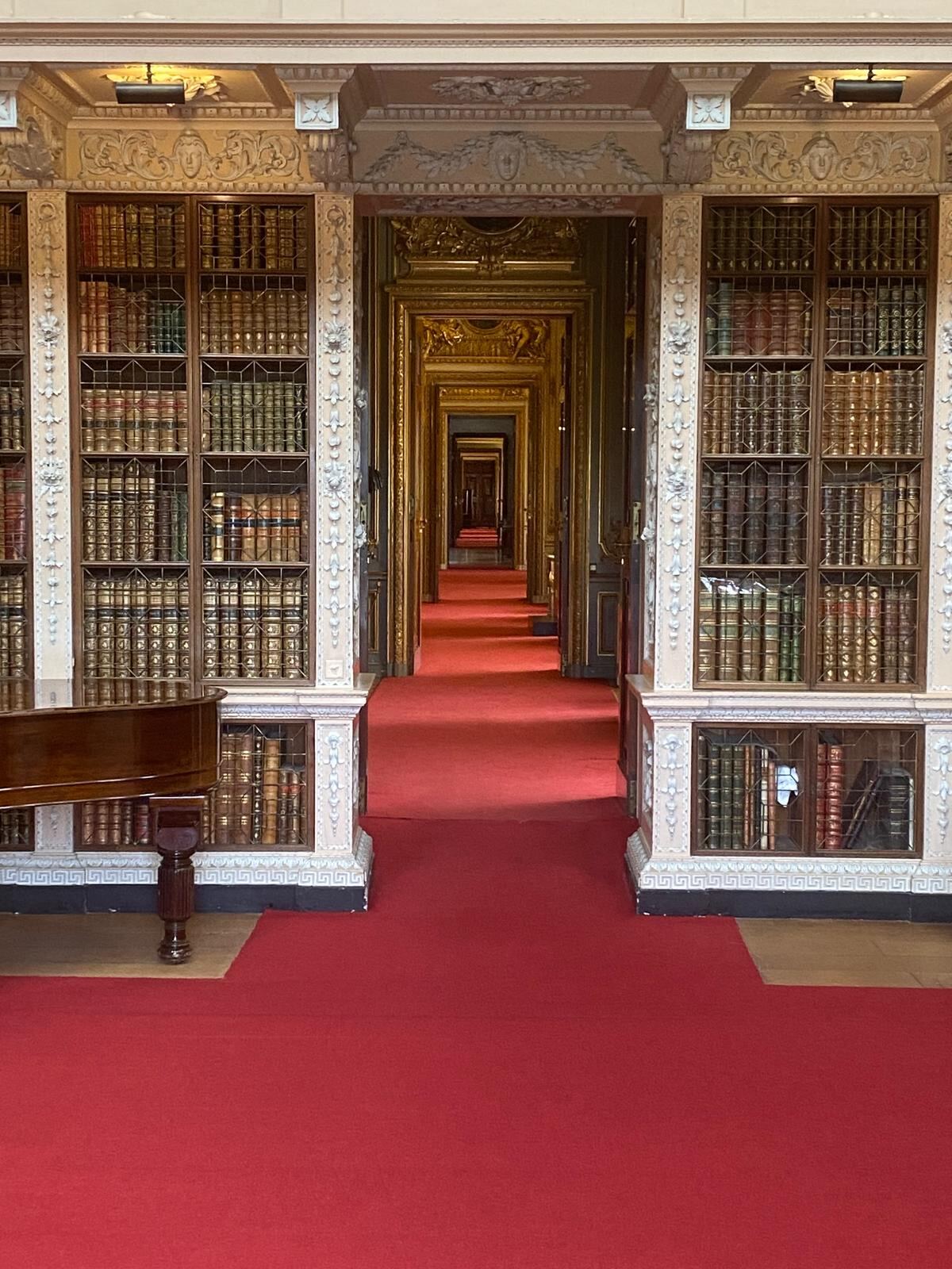 The Long Library enfilade at Blenheim Palace with gilded doorways and red carpet