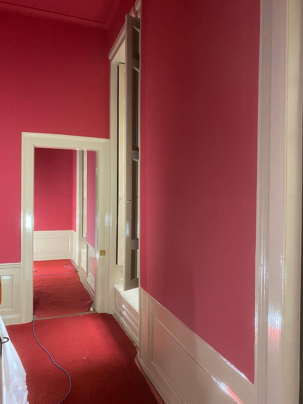 Freshly painted heritage red corridor with white wainscoting at Blenheim Palace, Woodstock Oxfordshire