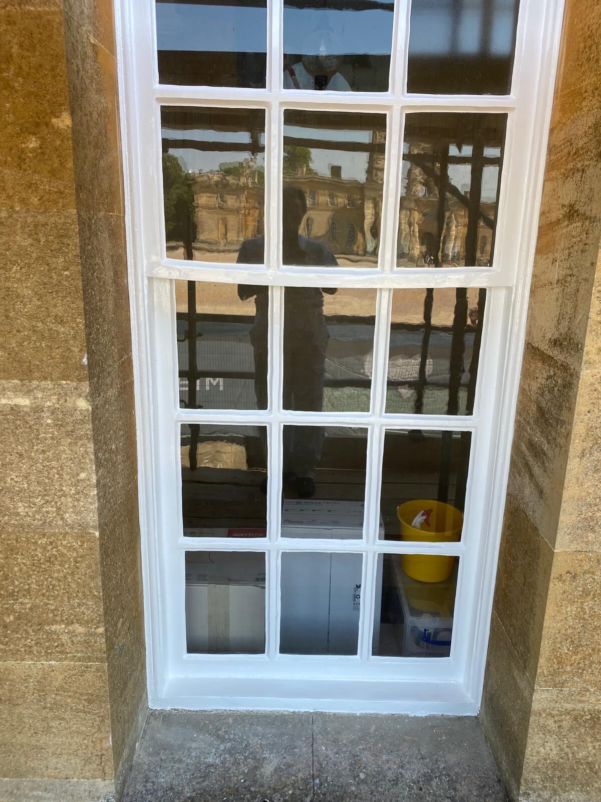 Close-up of newly painted Georgian sash window in Cotswold stone surround at Blenheim Palace