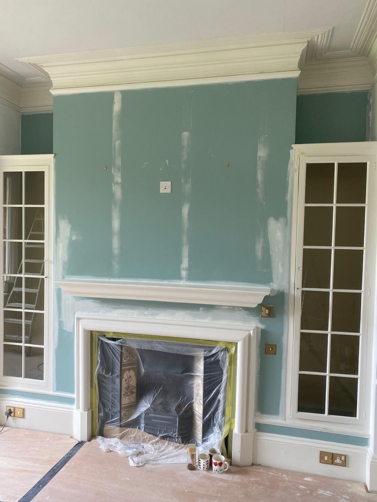 Teal-painted chimney breast with built-in glazed cabinets, Henley-on-Thames