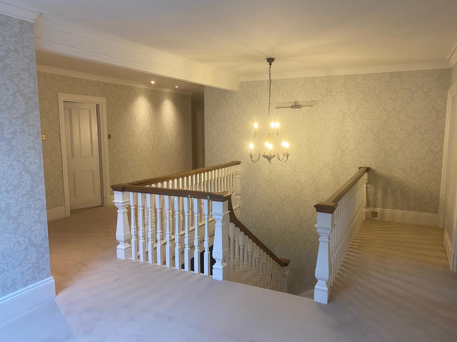 Pale grey damask wallpaper on a galleried landing in Oxfordshire